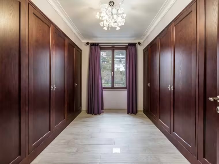 Dressing room with dark wood fitted wardrobes