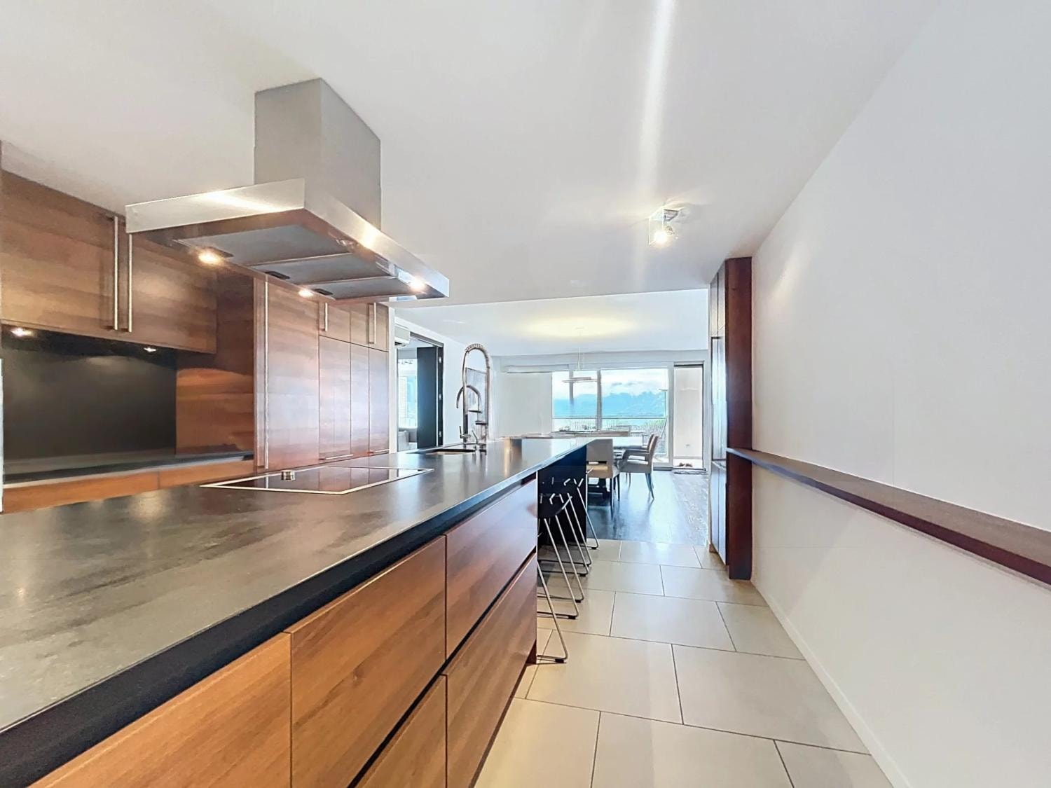 Designer kitchen with walnut cabinetry and open dining area, Le National, Montreux