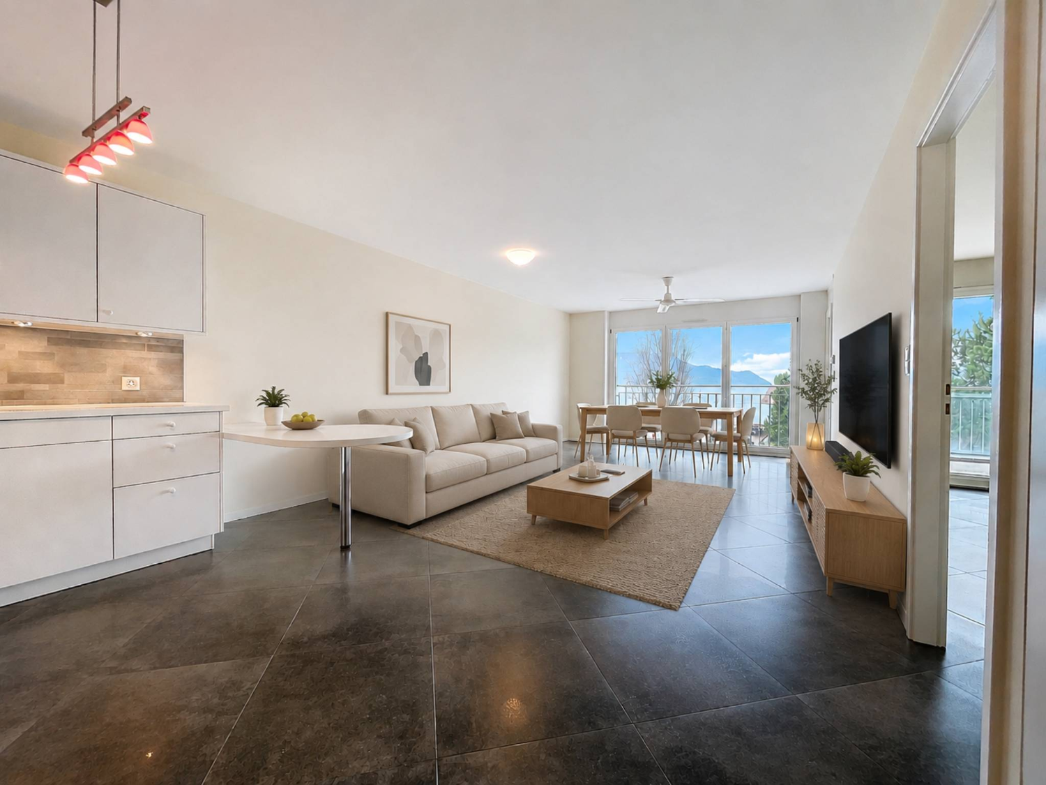 Bright living and dining area with open-plan kitchen and lake view balcony