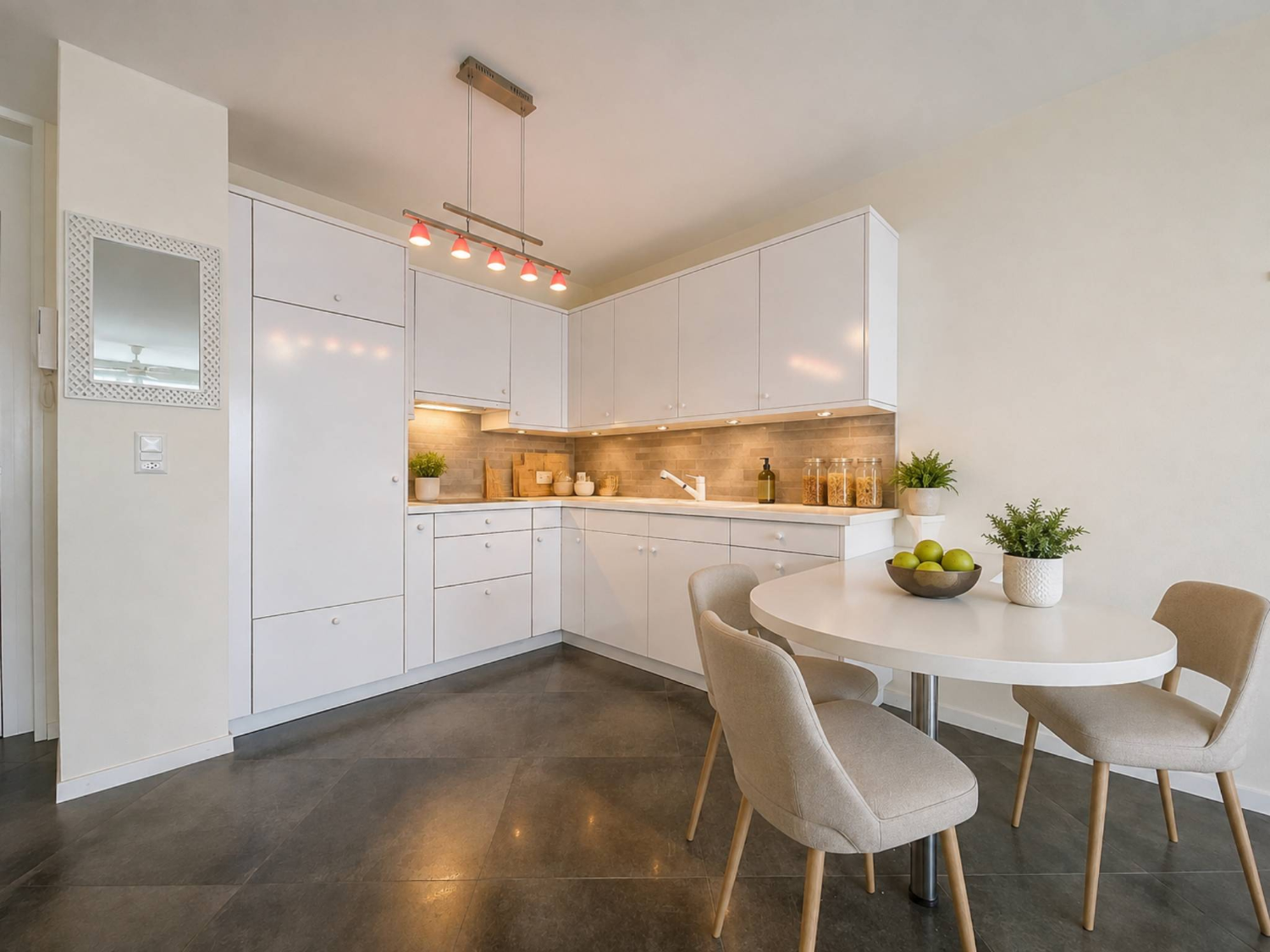 White fitted kitchen with dining area, central Montreux apartment