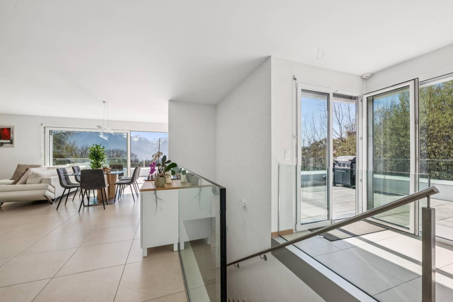 Bright living room with white leather sofa and terrace access, Montreux duplex penthouse