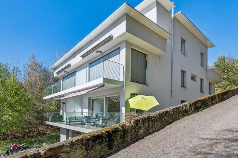 Interior duplex staircase with glass balustrade, open to living and dining area